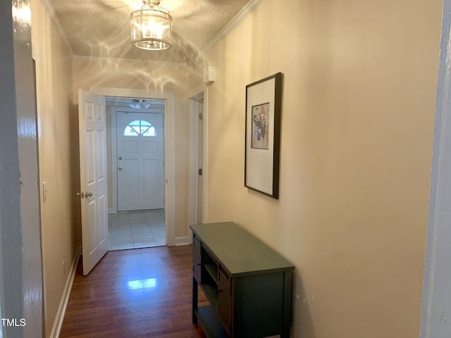 doorway to outside featuring dark wood-style floors, crown molding, and baseboards