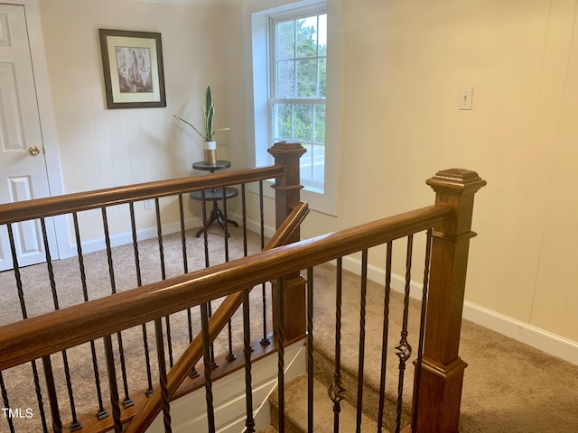 staircase with baseboards and carpet floors