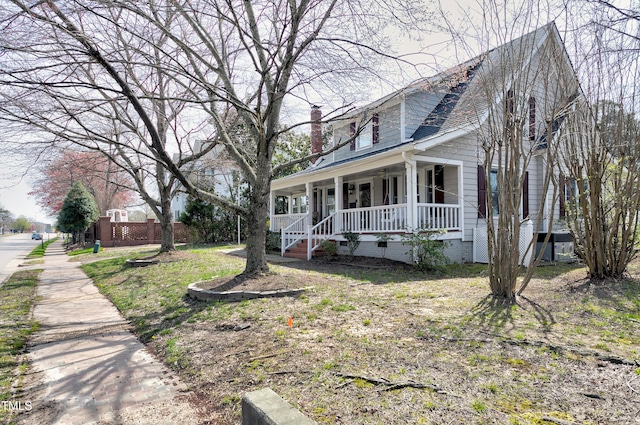 view of side of property featuring a porch and a chimney