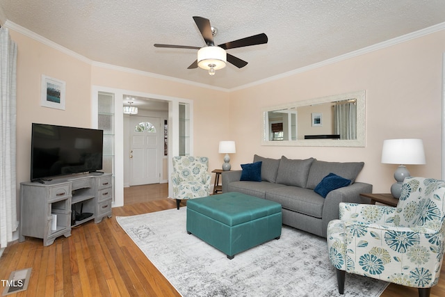 living room with a textured ceiling, ornamental molding, a ceiling fan, and hardwood / wood-style flooring