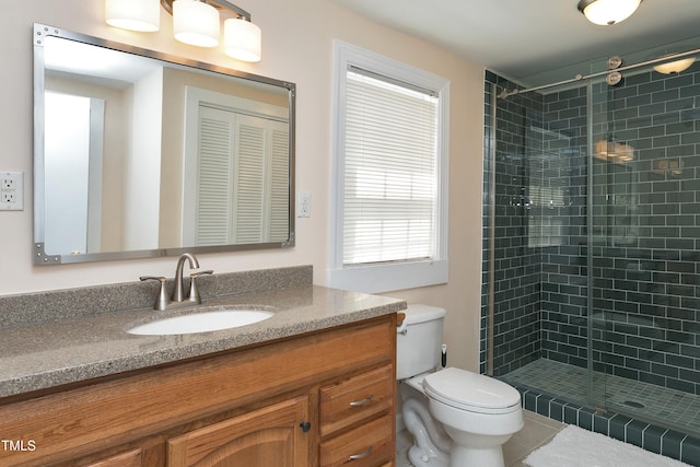 bathroom with vanity, tile patterned floors, toilet, and a stall shower