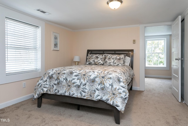 carpeted bedroom with crown molding, baseboards, and visible vents