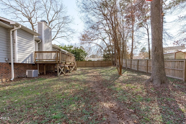 view of yard with a fenced backyard, a wooden deck, and central air condition unit