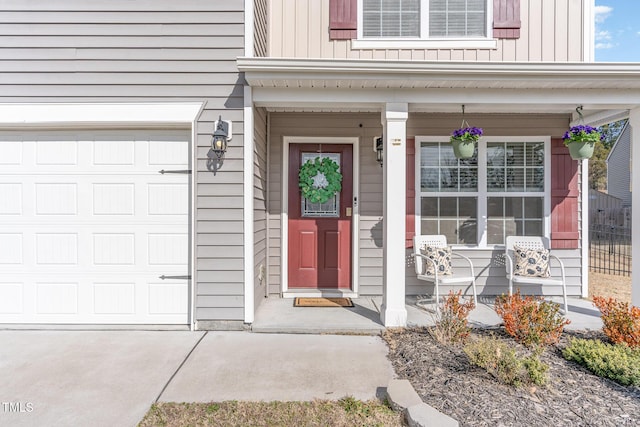 doorway to property featuring covered porch, board and batten siding, and an attached garage