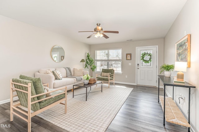 living room with visible vents, ceiling fan, baseboards, and wood finished floors