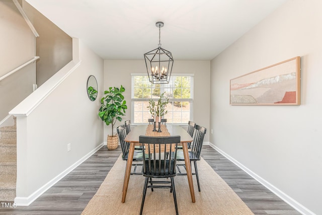 dining area with dark wood-style floors, baseboards, an inviting chandelier, and stairs