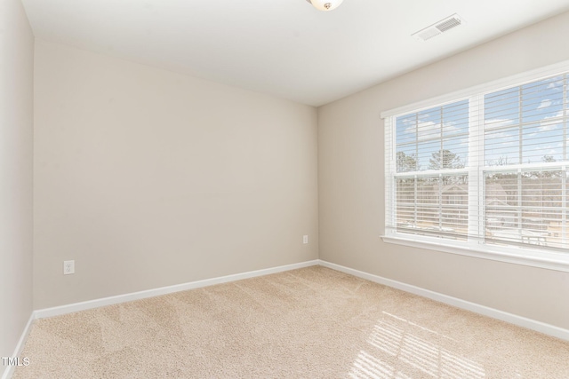 empty room featuring carpet floors, baseboards, and visible vents