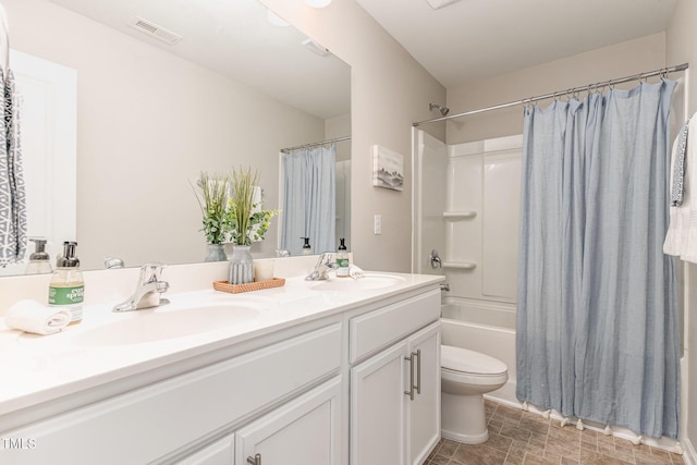 bathroom with visible vents, a sink, toilet, and double vanity