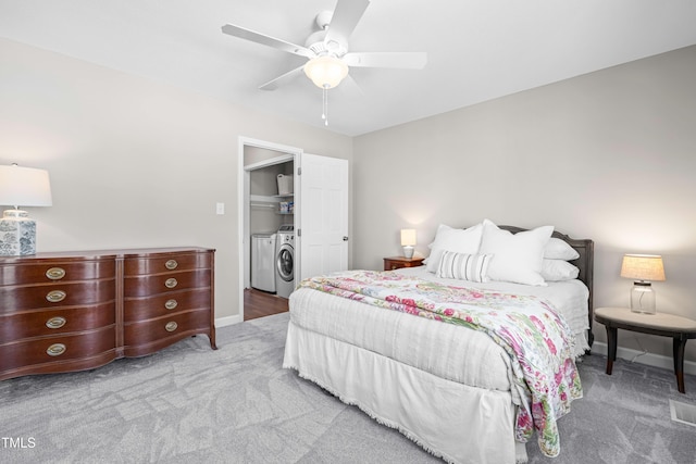 carpeted bedroom with a ceiling fan, baseboards, and separate washer and dryer