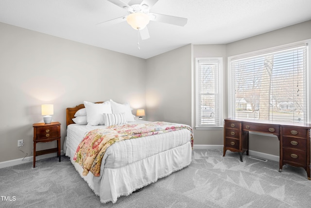 bedroom with a ceiling fan, light carpet, and baseboards