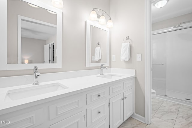 full bathroom with toilet, marble finish floor, a sink, and a stall shower