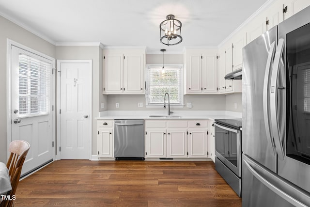 kitchen with light countertops, hanging light fixtures, appliances with stainless steel finishes, a sink, and under cabinet range hood