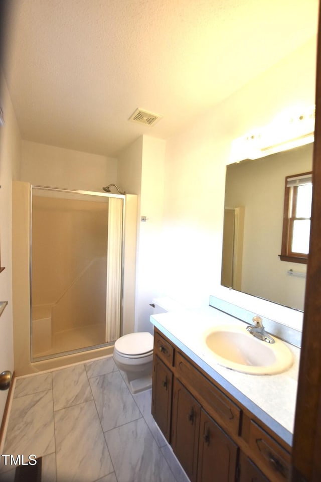 full bath featuring a stall shower, marble finish floor, visible vents, and vanity