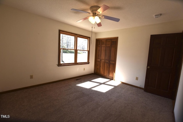 unfurnished bedroom featuring carpet floors, a textured ceiling, baseboards, and a closet