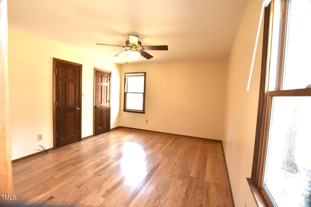 unfurnished bedroom with a ceiling fan, light wood-style flooring, and baseboards