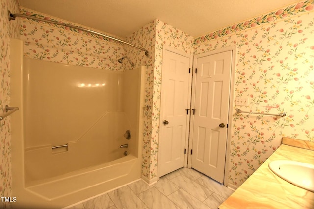 bathroom with wallpapered walls, vanity, marble finish floor, and shower / bathtub combination