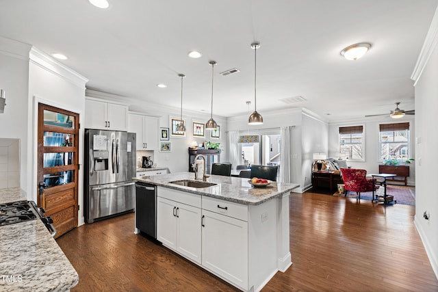 kitchen with a sink, visible vents, black dishwasher, stainless steel fridge, and crown molding