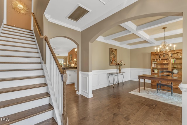 interior space featuring dark wood-type flooring, a chandelier, coffered ceiling, and beam ceiling