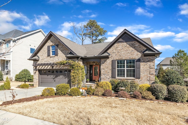 view of front of property featuring a garage, concrete driveway, brick siding, and a shingled roof