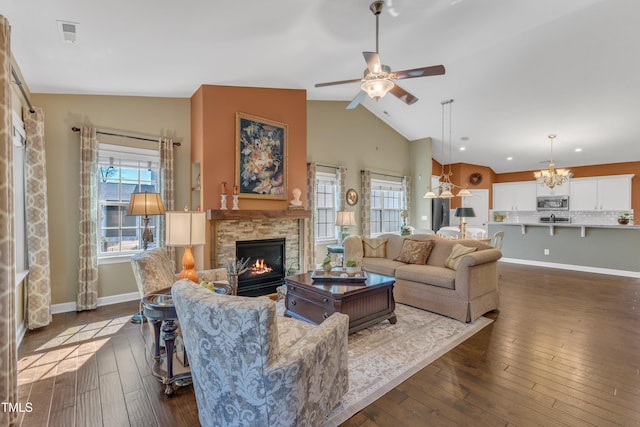 living room featuring lofted ceiling, dark wood-style flooring, plenty of natural light, and a fireplace