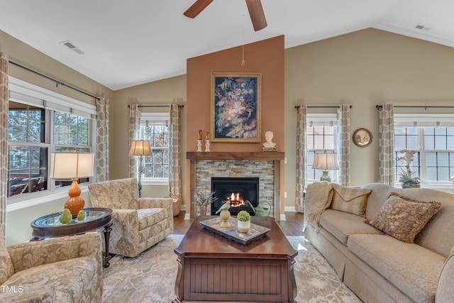 living area featuring a wealth of natural light, lofted ceiling, and visible vents