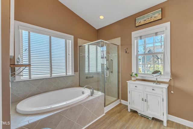 bathroom with a stall shower, baseboards, lofted ceiling, wood finished floors, and a bath