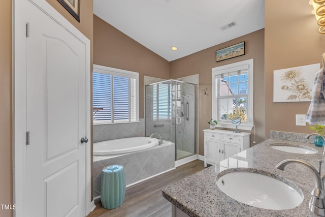 bathroom with a stall shower, visible vents, vaulted ceiling, and a sink