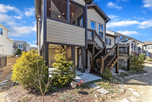 exterior space featuring a residential view, stairway, and a deck