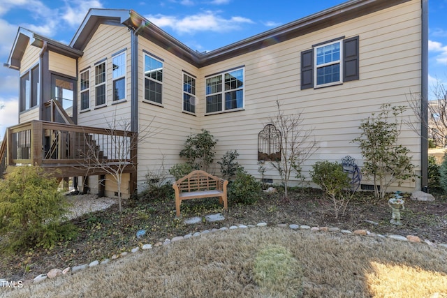 view of side of home with crawl space and stairway