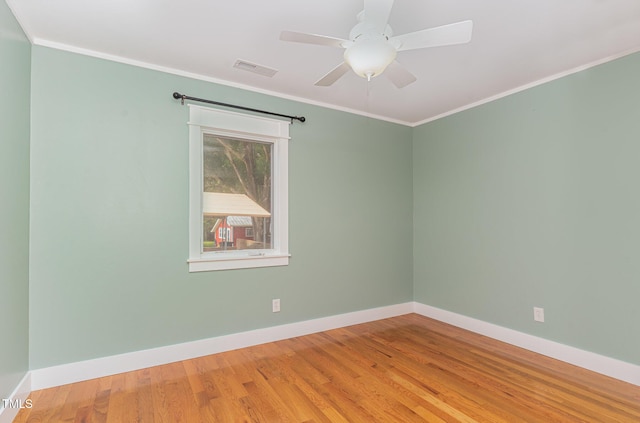 unfurnished room with baseboards, visible vents, ceiling fan, ornamental molding, and wood finished floors