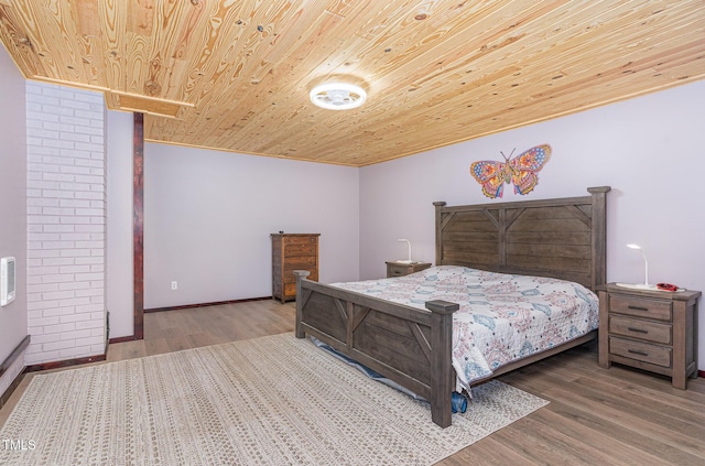 bedroom with wooden ceiling, baseboards, and wood finished floors