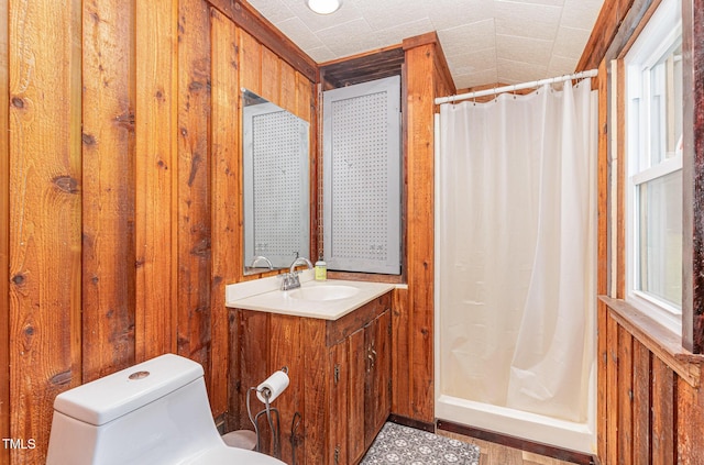 bathroom featuring toilet, a stall shower, and wooden walls