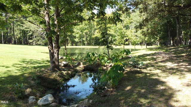 exterior space featuring a water view and a wooded view