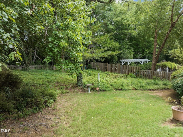 view of yard featuring fence and a pergola