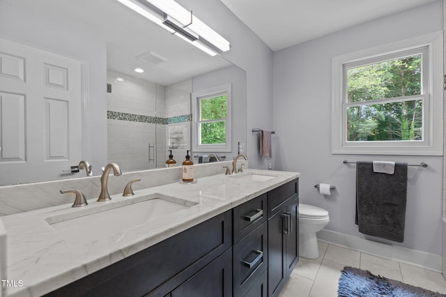 full bathroom featuring double vanity, a stall shower, baseboards, tile patterned flooring, and a sink