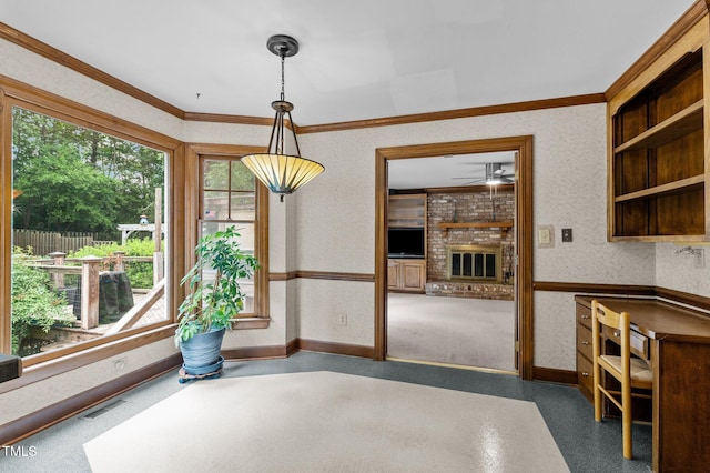 unfurnished dining area with crown molding, a brick fireplace, visible vents, and wallpapered walls