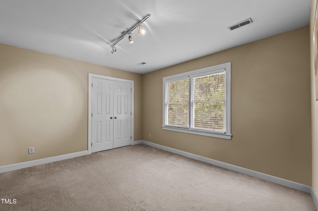 unfurnished bedroom featuring baseboards, a closet, visible vents, and carpet flooring