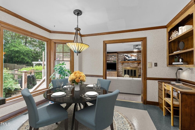 dining room featuring crown molding, a brick fireplace, and wallpapered walls