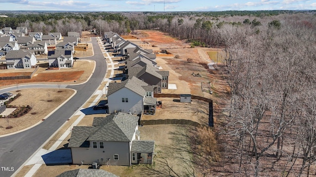 drone / aerial view with a wooded view and a residential view