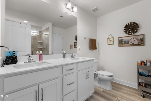 bathroom with toilet, a stall shower, visible vents, and a sink