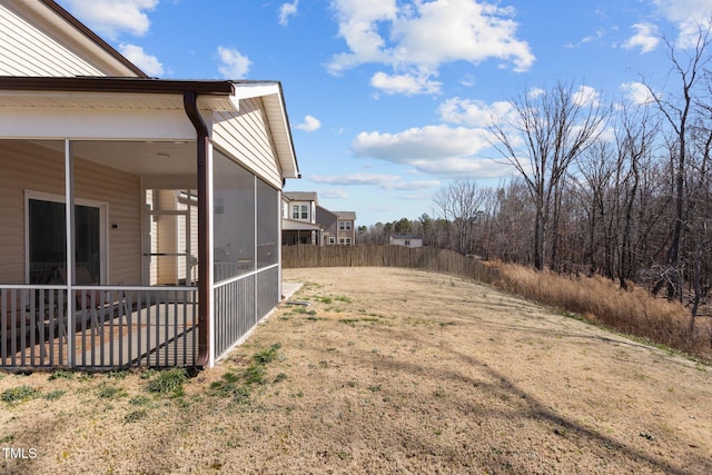 view of yard with a sunroom and fence