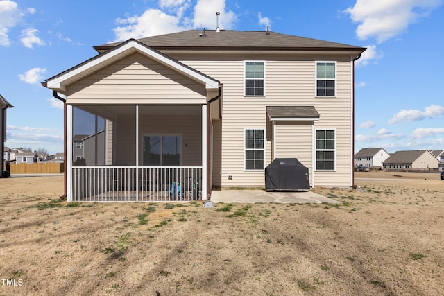 rear view of house featuring a sunroom and a patio area