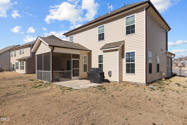 rear view of property featuring a sunroom and a patio area