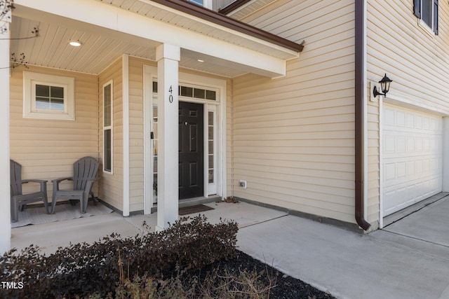 entrance to property featuring a garage and covered porch