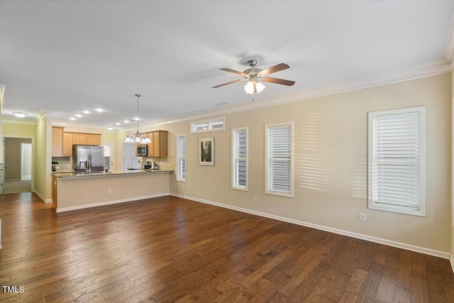 unfurnished living room featuring baseboards, dark wood finished floors, crown molding, and ceiling fan with notable chandelier