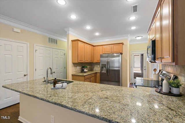 kitchen featuring appliances with stainless steel finishes, visible vents, a sink, and light stone countertops