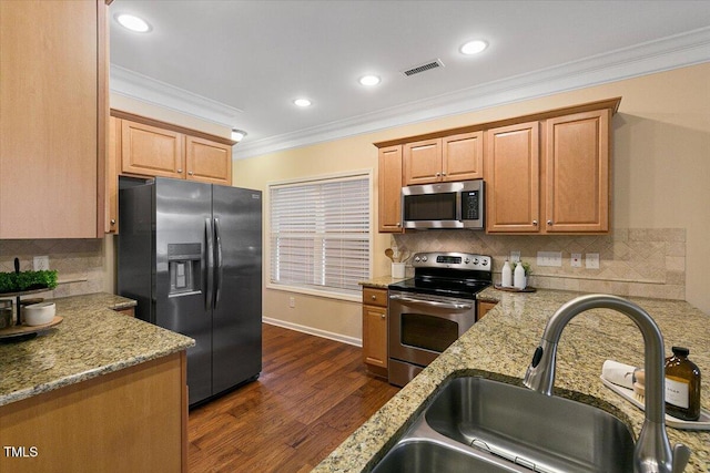 kitchen featuring dark wood-style floors, visible vents, appliances with stainless steel finishes, ornamental molding, and a sink