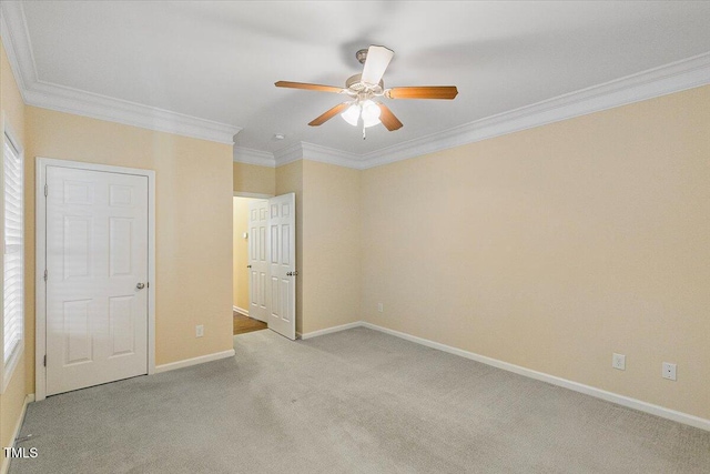 unfurnished bedroom with ornamental molding, light carpet, baseboards, and a ceiling fan