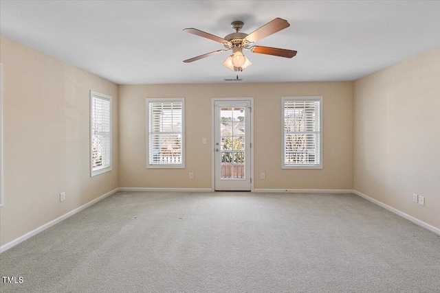 unfurnished room featuring a ceiling fan, light carpet, and baseboards