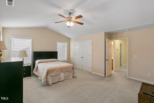 bedroom featuring lofted ceiling, a closet, visible vents, light carpet, and baseboards